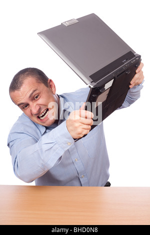Angry businessman fracassant son ordinateur portable sur la table Banque D'Images