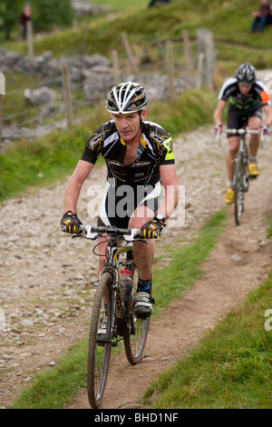 Cyclistes roulent un sentier de terre pendant les trois sommets Cyclo-Cross dans Yorkshire, Royaume-Uni Banque D'Images