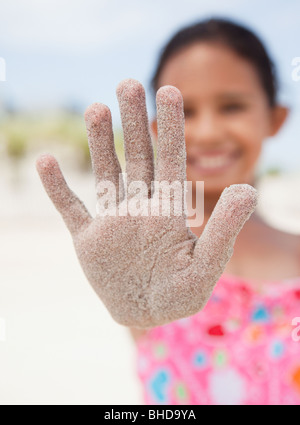 Hispanic girl afficher main couverte de sable