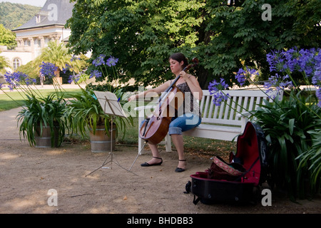 Jeune femme jouant du violoncelle dans des jardins de Schloss Pillnitz Dresde Banque D'Images