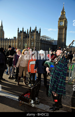 Cornemuse sur Westminster Pier jouant pour les touristes à Londres Banque D'Images