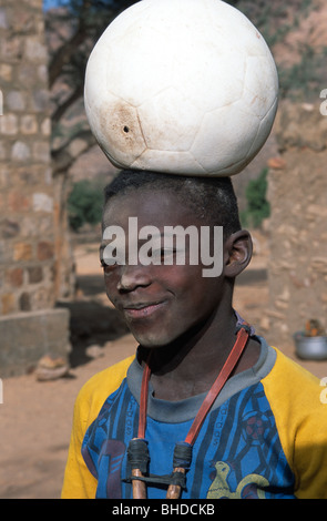 Un garçon avec un football dégonflé sur sa tête, Tereli, Pays Dogon, au Mali. Banque D'Images