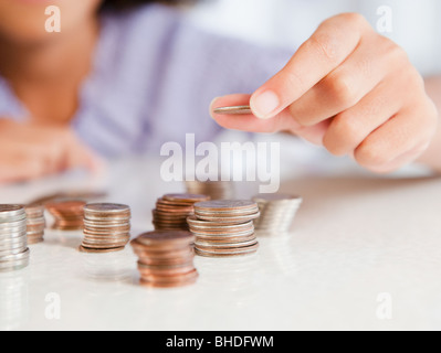 Hispanic girl stacking coins Banque D'Images