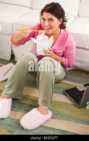 Mixed Race woman eating take-out Banque D'Images