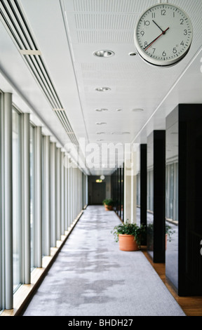 Hall intérieur du Parlement Canberra Australie // CANBERRA, Australie — le Parlement est le lieu de réunion du Parlement australien. Cette image capture un couloir intérieur moderne dans le bâtiment, avec de grandes fenêtres, un long sol recouvert de moquette et une horloge suspendue au plafond. Le bâtiment, situé à Canberra, la capitale de l'Australie, a été inauguré le 9 mai 1988 par la reine Elizabeth II, reine d'Australie. Son coût de construction s'élevait à plus de 1,1 milliards de dollars, ce qui en faisait le bâtiment le plus cher de l'hémisphère sud au moment de sa construction. Avant 1988, le Parlement Banque D'Images