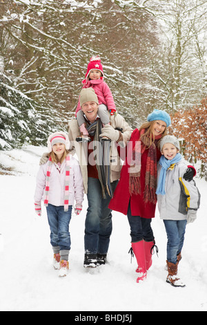 Balades en famille à travers des bois enneigés Banque D'Images