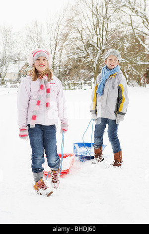 Les enfants tirant par traîneau Paysage de neige Banque D'Images