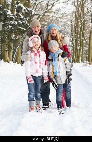 Balades en famille à travers des bois enneigés Banque D'Images