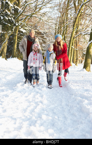 Balades en famille à travers des bois enneigés Banque D'Images