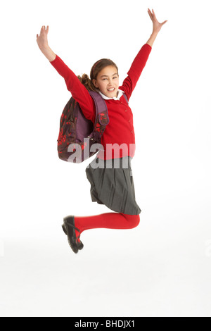 Happy Female Student en uniforme dans l'air de saut Banque D'Images