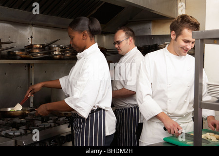 Équipe de Chefs Preparing Food In Restaurant Kitchen Banque D'Images