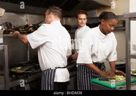 Équipe de Chefs Preparing Food In Restaurant Kitchen Banque D'Images