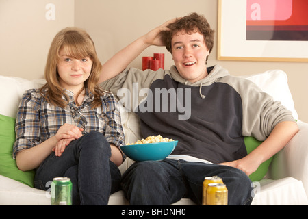 Teenage Couple Sitting on Sofa watching TV Banque D'Images