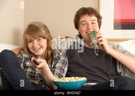 Teenage Couple Sitting on Sofa watching TV Banque D'Images