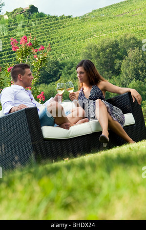 Young couple sitting on couch en vigne au vin blanc Banque D'Images