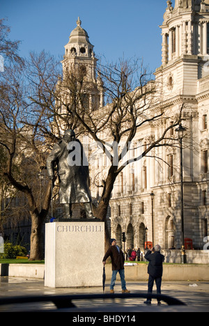 Tourist posant devant la Statue de Winston Churchill, la place du Parlement, Londres, Angleterre, Royaume-Uni, Europe Banque D'Images