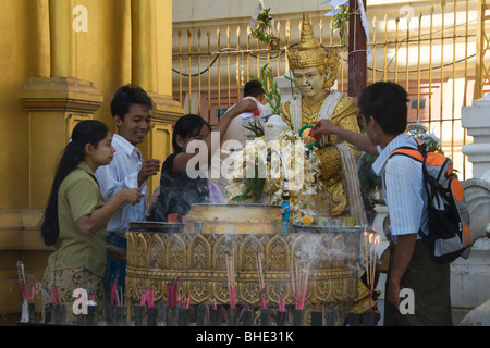 Les dévots prient, verser de l'eau et en faisant des offrandes au Bouddha, Rangoon, Birmanie, Myanmar, Yangon Banque D'Images