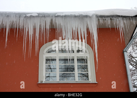 Gros glaçons pendant d'une gouttière sur une maison à Tallinn, Estonie. Banque D'Images