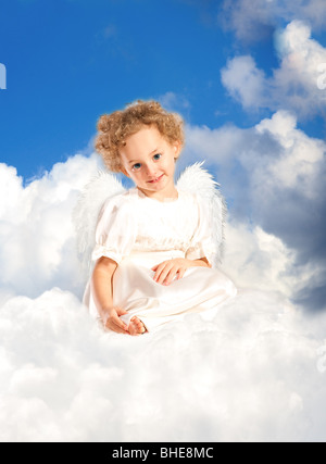 Peu curly girl avec fairy wings se trouve sur un nuage Banque D'Images