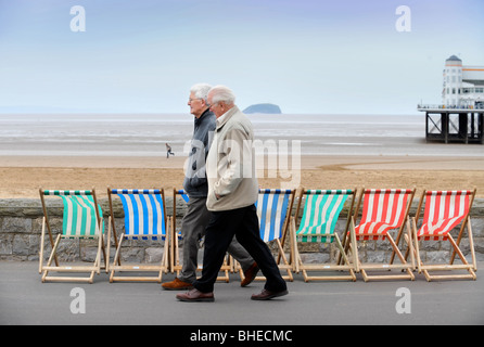 Transats au bord de la mer avec l'île de Holm mur raide sur l'horizon à Weston-Super-Mare, Somerset UK Banque D'Images