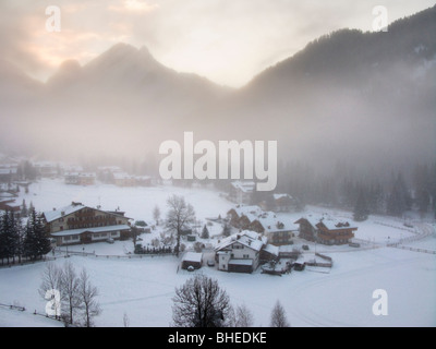 Canazei, Val di Fassa, Dolomites, Italie. Station de ski de Sella Ronda sur circuit. Brume matinale dans la vallée. Banque D'Images