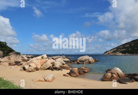 Ciel bleu, mer bleue, rochers de granit sur la plage, dans une baie au bord de la mer de Chine du Sud, près de Tun O, Lamma Island, Hong Kong Banque D'Images