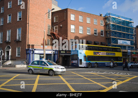 Garde, la police et d'autobus au coin de St Stephen Green et Lower Leeson Street . Dublin. L'Irlande. Banque D'Images