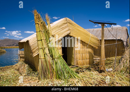 Abris fabriqués à partir de roseaux totora et un panneau solaire, le mélange ancien et la technologie moderne. Îles des Uros, Lac Titicaca, Pérou Banque D'Images