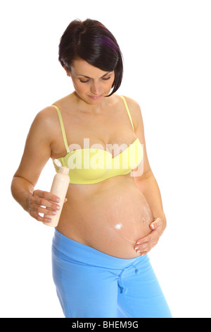 Femme enceinte de mettre de la crème sur son ventre pour éviter les vergetures Banque D'Images