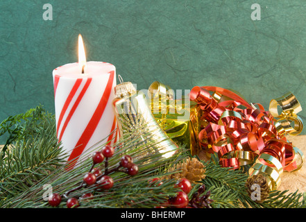 Rayé rouge et blanc bougie de Noël avec de l'or rouge et ornement bell ruban frisé Banque D'Images