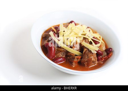 Un bol de chili au bœuf, chili con carne, garnir de fromage, plus de blanc avec une ombre légère Banque D'Images