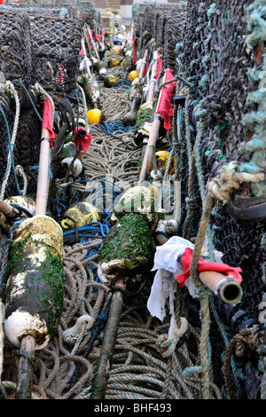 Des rangées de casiers à homard empilés sur le quai avec des bouées. Banque D'Images