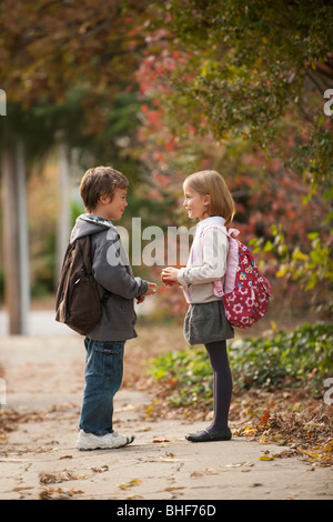 Mixed Race brother and sister walking on sidewalk Banque D'Images