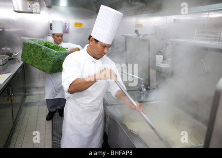 Cuisine à bord d'un navire de croisière, les cuisiniers dans le kitching comment préparer les légumes, un paquebot de croisière Queen Mary 2 Banque D'Images