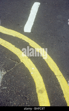 Détail de la double lignes jaunes avec bords flous coin rond incurvé ou plier avec une seule ligne blanche à angle droit pour eux Banque D'Images