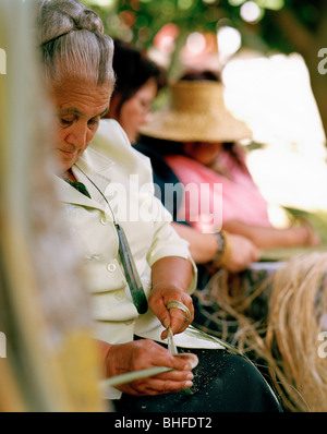 Femme maorie maorie à feuilles de lin grincant et musée colonial, Okains Bay, la péninsule de Banks, île du Sud, Nouvelle-Zélande Banque D'Images