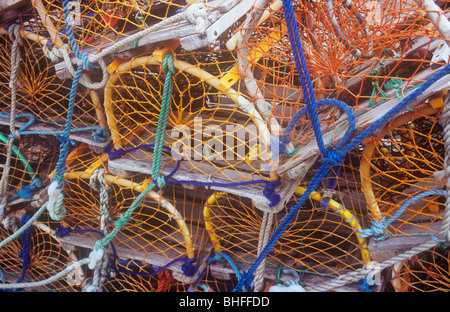 Close up de casiers à homard empilés en bois et filet en nylon orange et liés avec de la corde de nylon bleu ou vert Banque D'Images