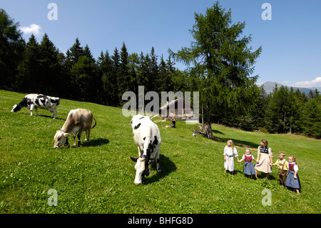 Les vaches sur une prairie alpine, les enfants jouant sur l'herbe, de l'Agriculture, agritourisme, Tyrol du Sud, Italie Banque D'Images