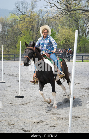 Happy rider s'amusant sur un cheval en passant par le pôle Fibres compétition à un spectacle événement. Banque D'Images