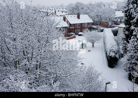 Une voiture arrondit un coin dans un village couvert de neige vue d'un pont élevé tôt le matin Banque D'Images