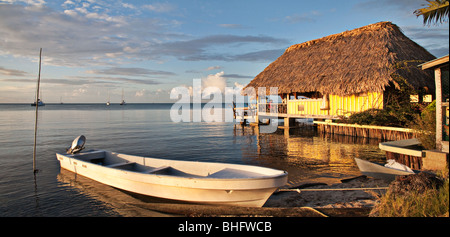 Bar dans une cabane au toit de chaume dans l'eau sur une plage de Placencia, Belize Banque D'Images