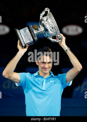 Roger Federer (SUI) tenant le trophée gagnants en l'air à l'Open d'Australie 2010 à Melbourne, Australie Banque D'Images