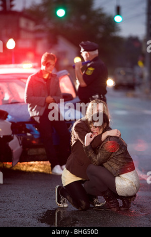 Les jeunes et l'agent de police lors d'accident de voiture Banque D'Images