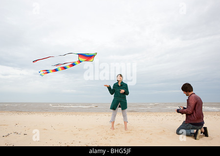 Couple sur une plage avec kite Banque D'Images