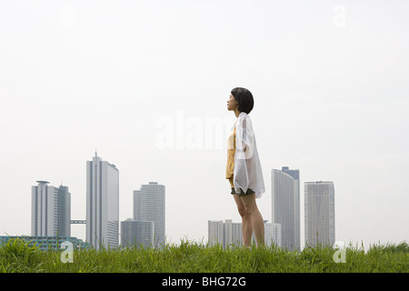 Jeune femme en face de city skyline Banque D'Images
