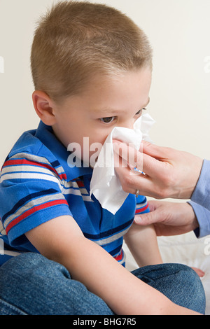 Boy blowing nose Banque D'Images