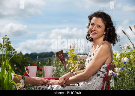 Femme assise sur balcon holding hand Banque D'Images