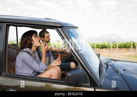 Woman putting on lipstick en véhicule Banque D'Images
