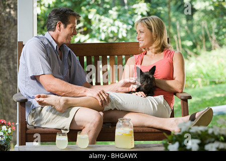 Couple sur banc avec chien Banque D'Images