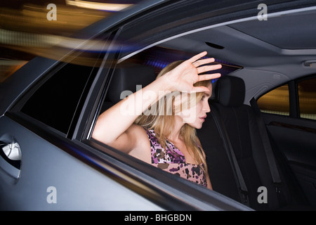 Woman with hand soulevées à la fenêtre de voiture Banque D'Images